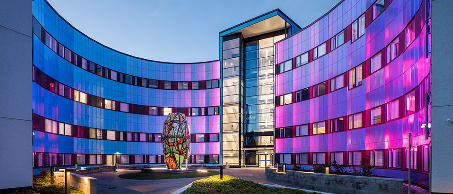 A building lighted by blue and purple lights.