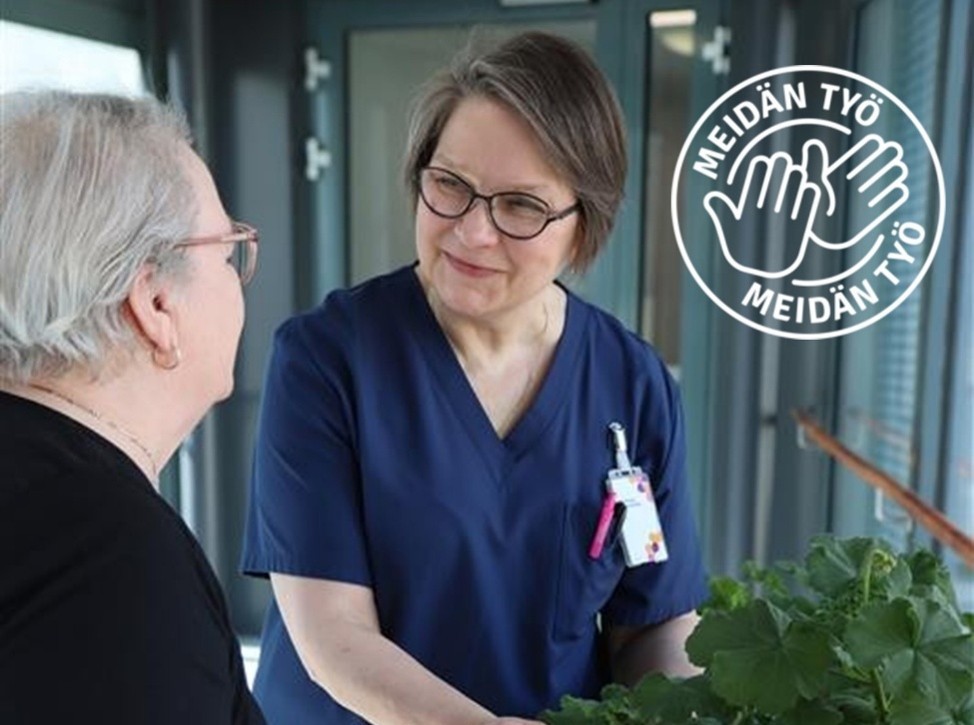 Työntekijä ja asiakas keskustelevat kasvien äärellä.