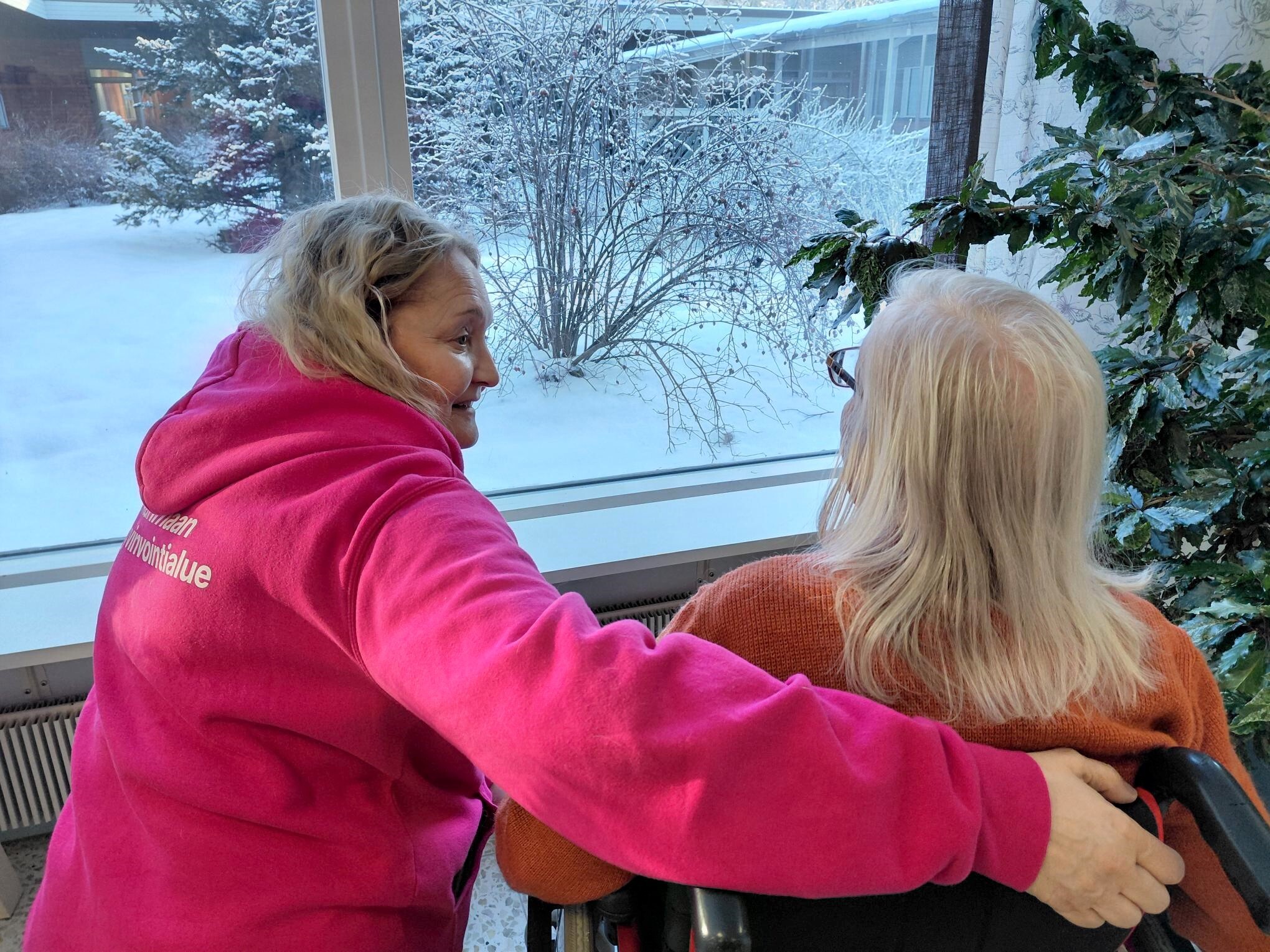 Pirkanmaan hyvinvointialueen työntekijä ja ikäihminen ovat ikkunan edessä.