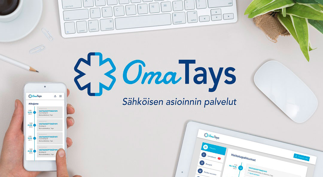 Näppäimistö, tabletti ja kännykkä pöydällä ja kuvan keskellä on