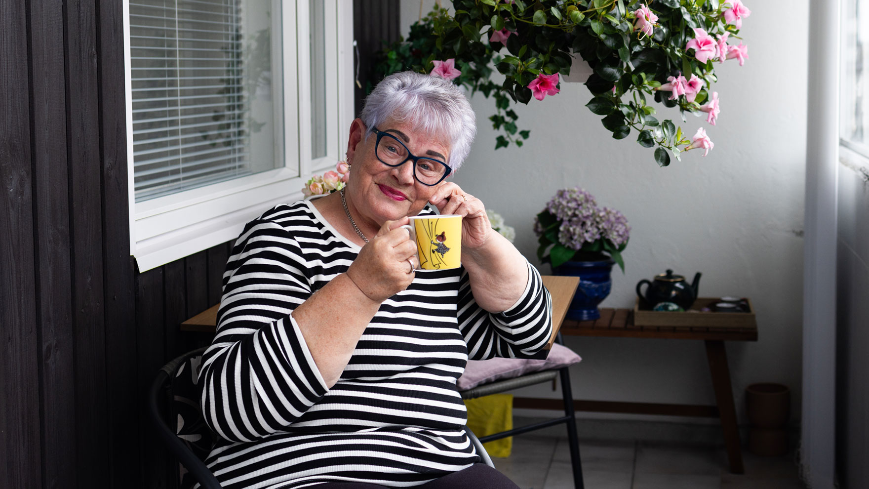 Nainen nauttimassa kahvia terassilla.