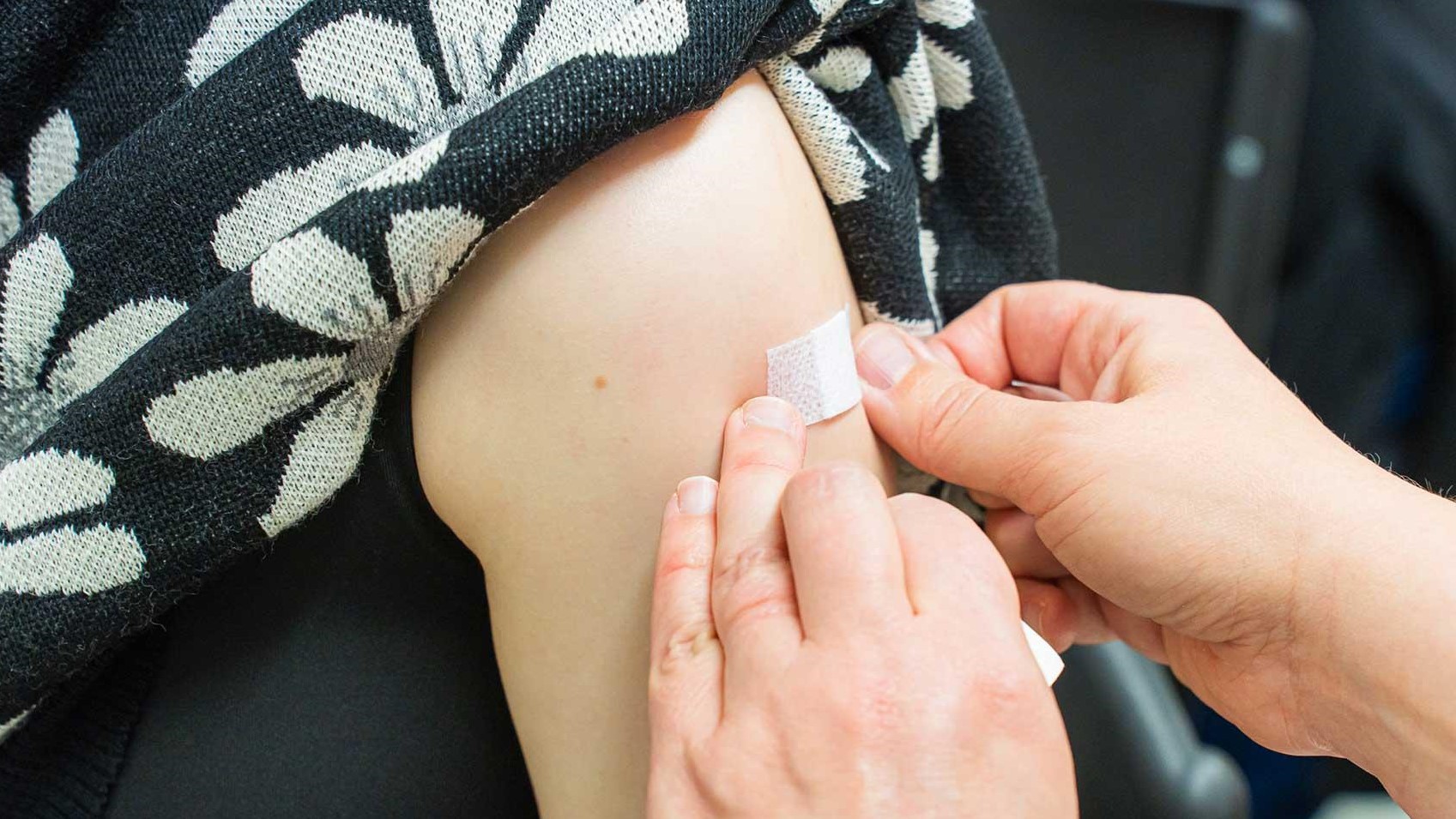 Käsivarteen painetaan rokotuslaastari.