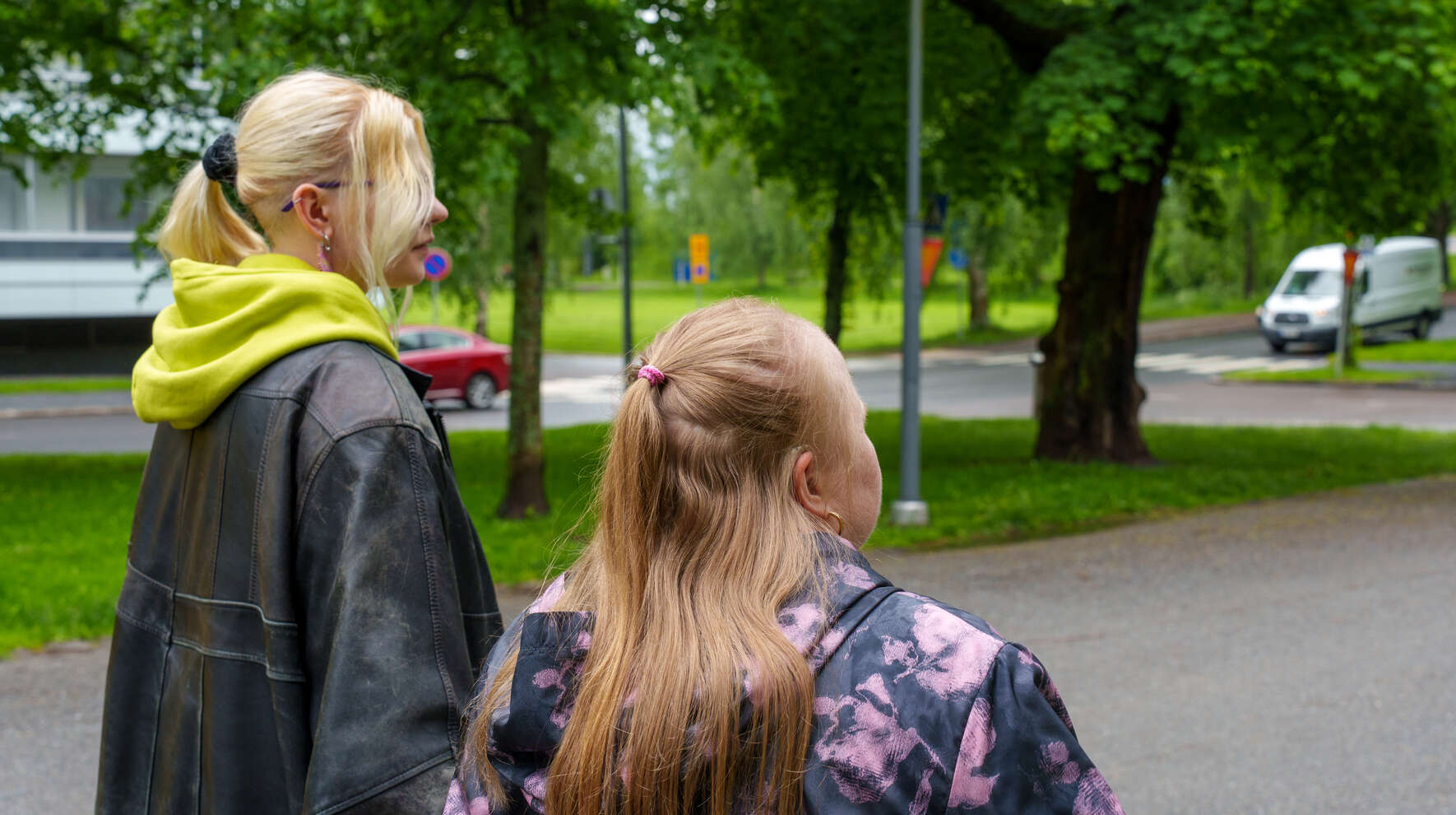 Kaksi henkilöä kävelee puistossa.