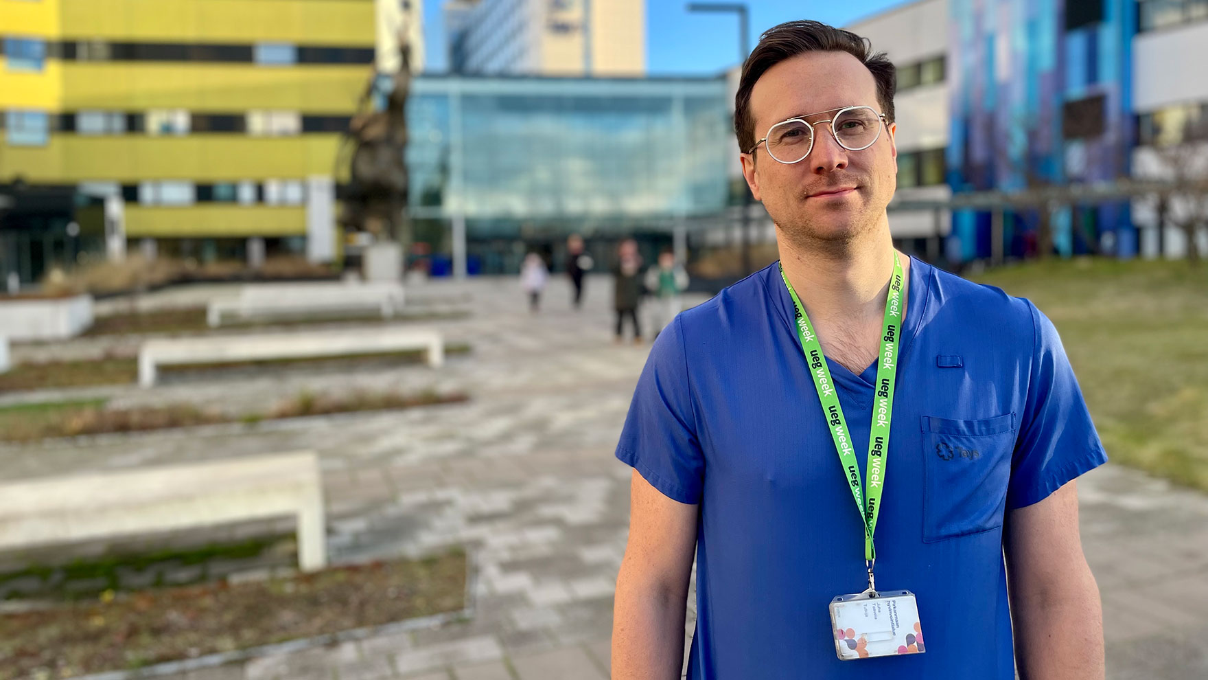 Juha Taavela seisoo Tays Keskussairaalan etupihalla työvaatteissaan.