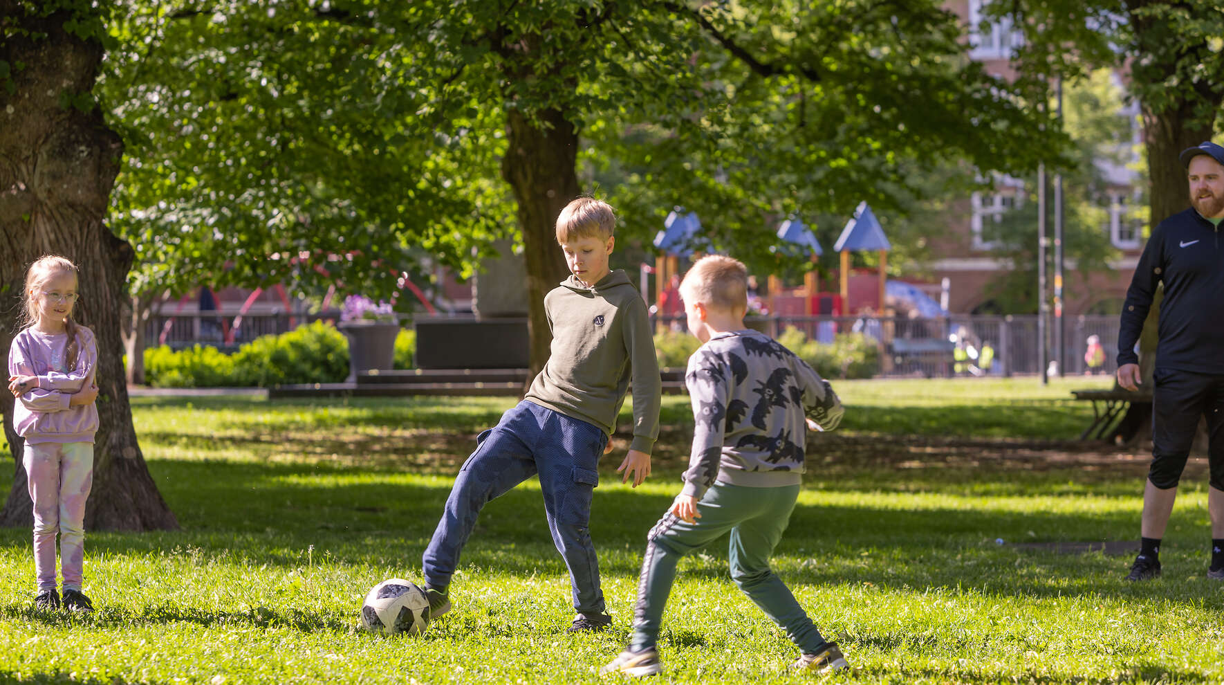 Lapsia pelaamassa palloa puistossa.