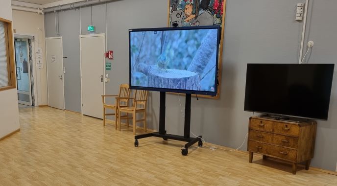 Clevertouch-laite Havulinnan aulassa. Laitteella pyörii lintuvideo.