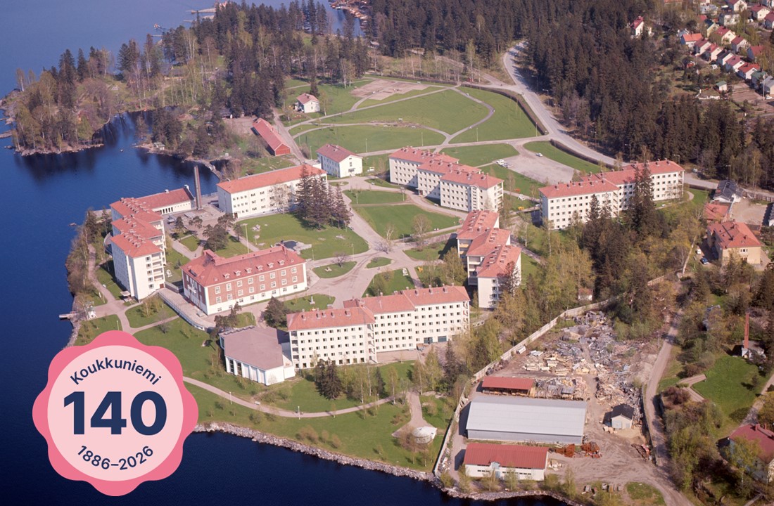 Vanha ilmakuva Koukkuniemen alueesta sekä Koukkuniemi 140 -leima sen päällä.
