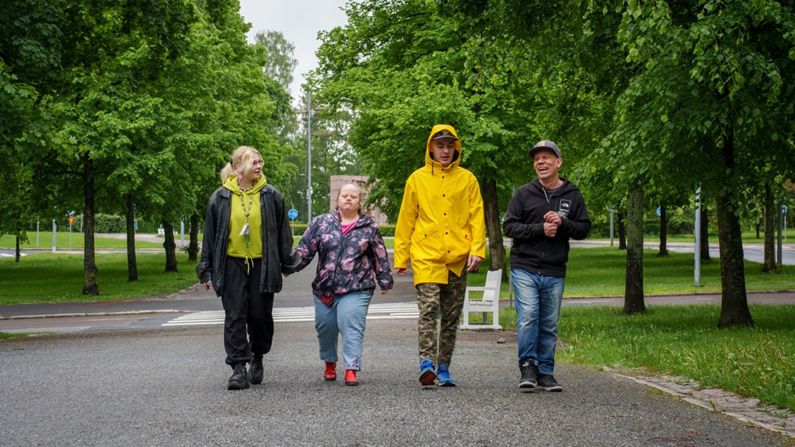 Kehitysvammaiset ja ohjaaja kävelevät ulkona.