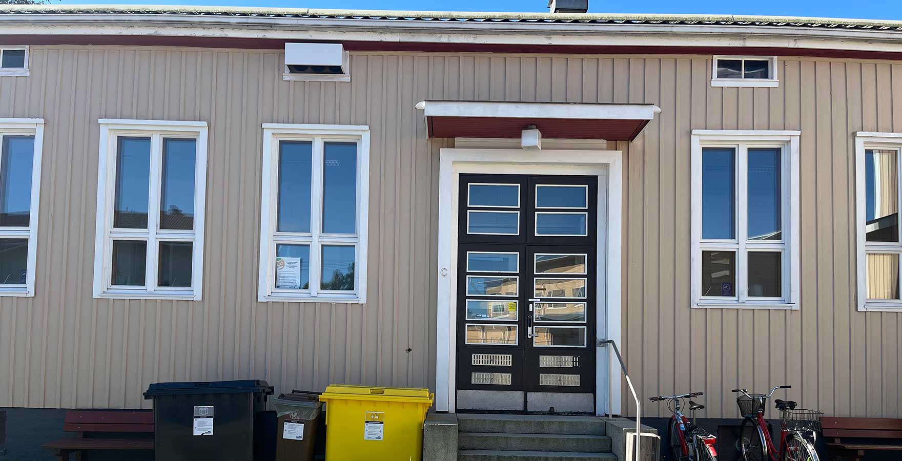 Okranvärisen puutalon sisäänkäynti.