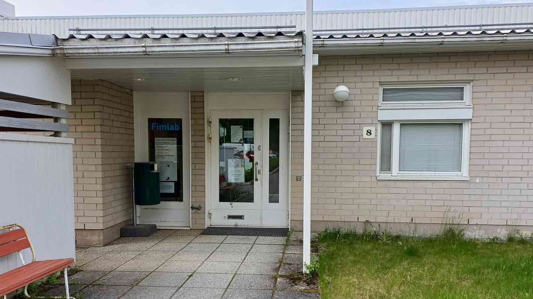 Sisäänkäynti vaaleatiilisessä rakennuksessa