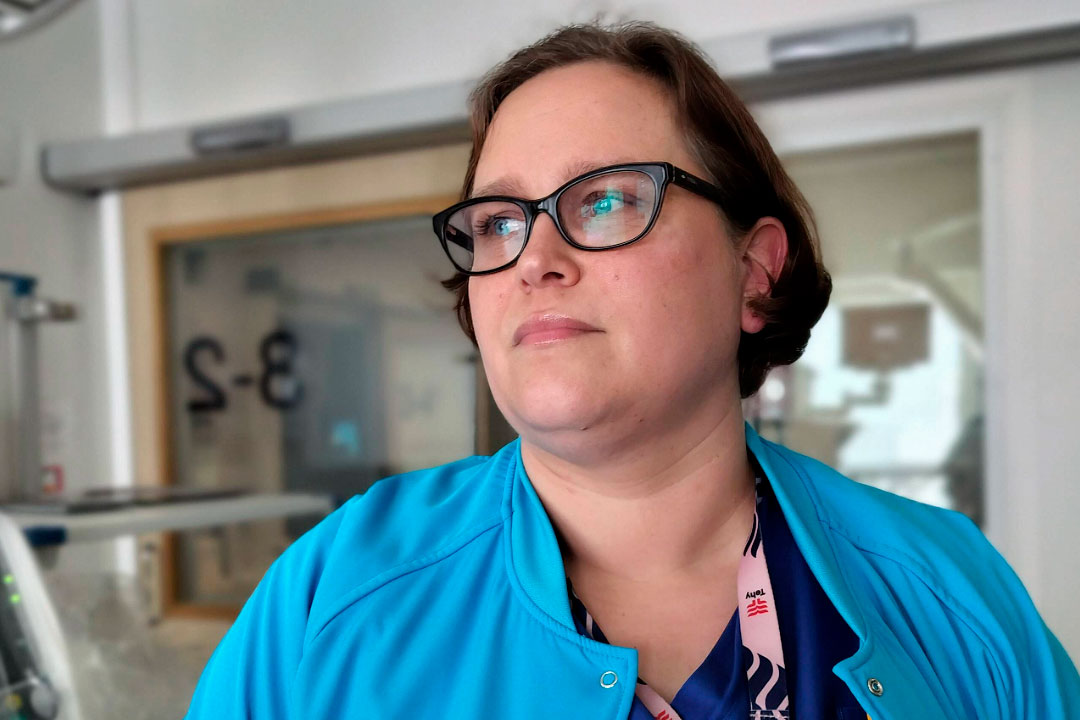 Maria katsoo miettivänä eteenpäin. Taustalla näkyy potilashuonetta.