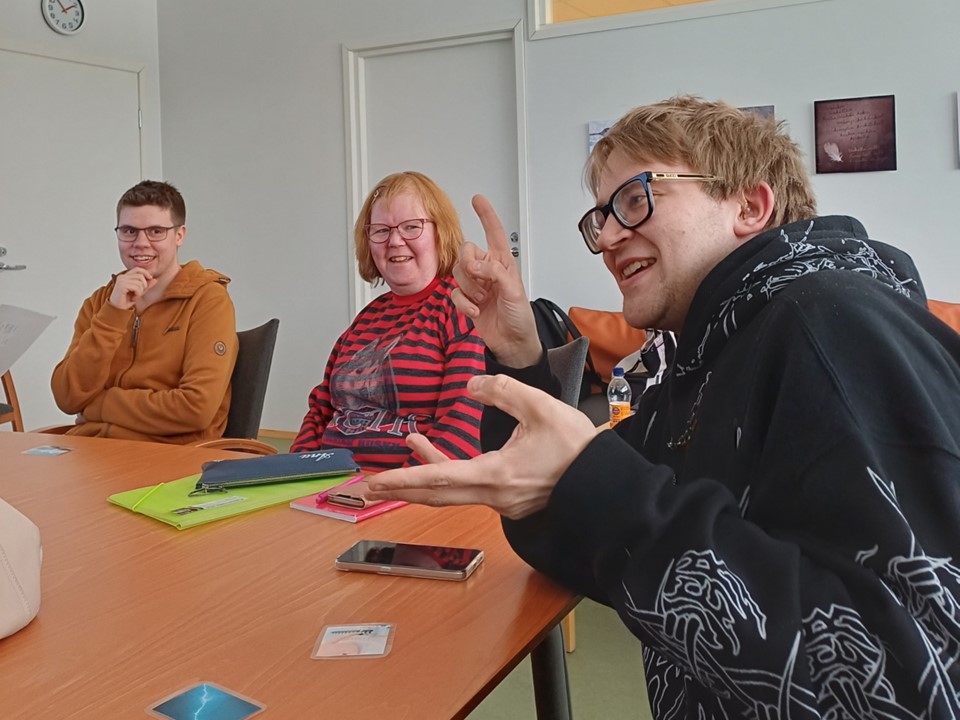 Nuoria istuu pöydän ääressä keskustelemassa.