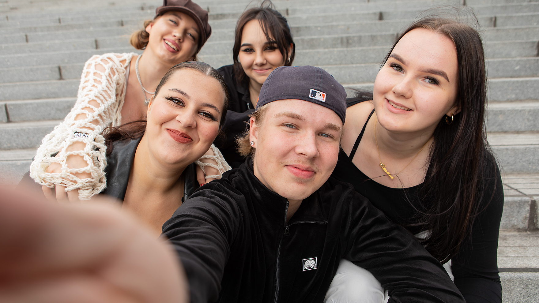 Joukko nuoria ottaa kuvaa itsestään puhelimella.