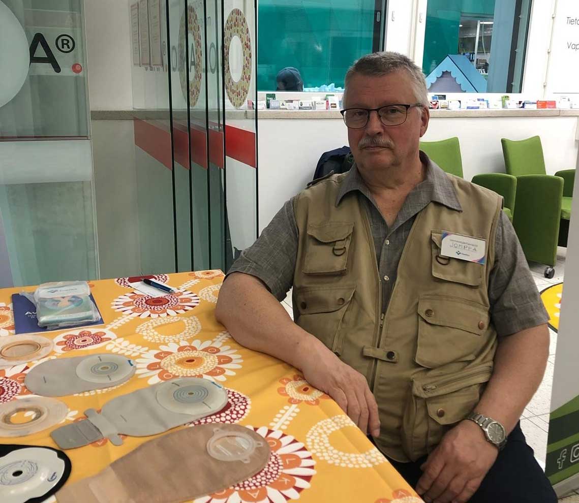 Vertaistukija istuu OLKA-pisteellä pöydän ääressä.