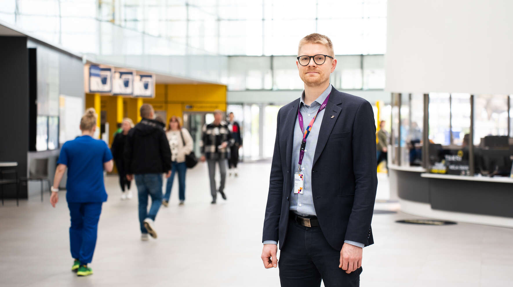 Olli Leppänen Taysin pääaulassa. Taustalla kulkee ihmisiä.