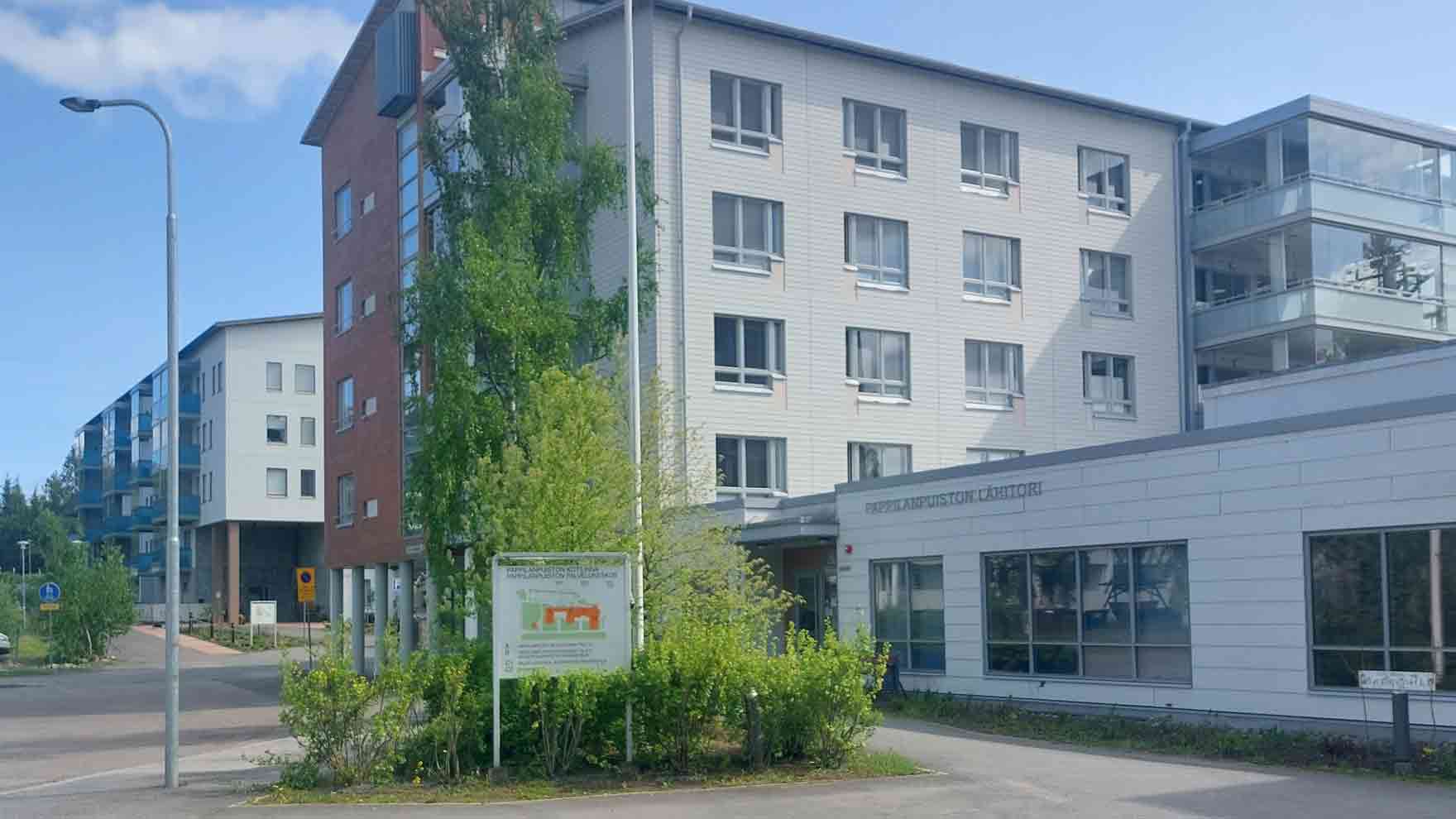 Korkea rakennus ja matalampi siipi, jossa lukee Pappilanpuiston lähitori