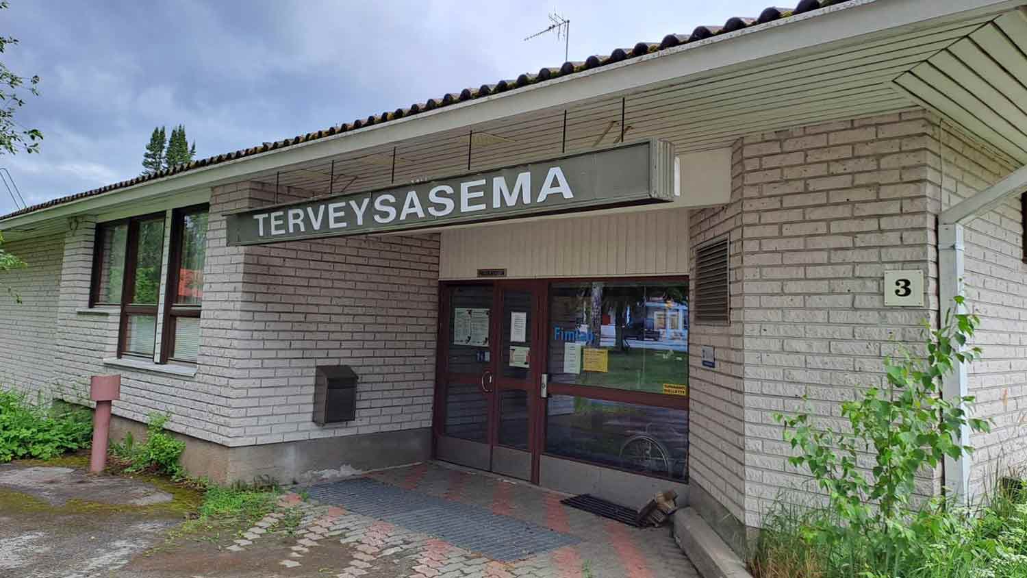 Vaaleatiilinen rakennus, jonka sisäänkäynnin päällä teksti terveysasema