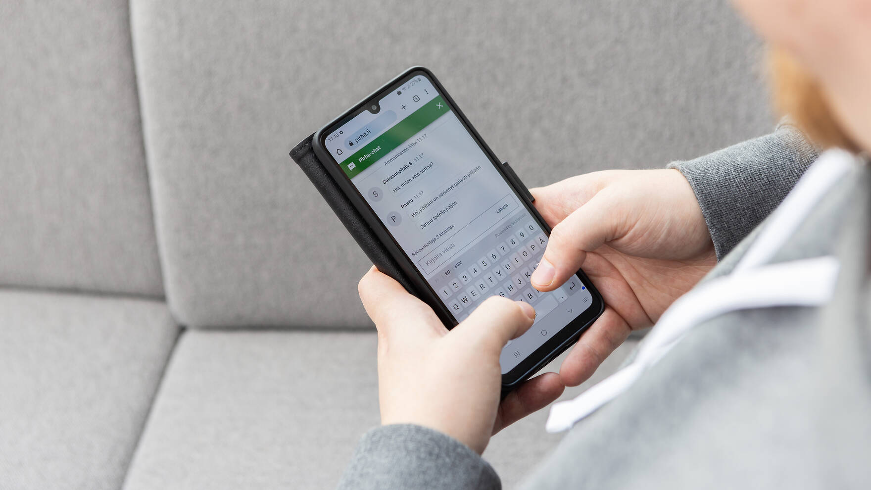 Mieshenkilö kirjoittaa mobiilipuhelimen näppäimistöllä.