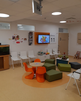 Lastenkirurgian poliklinikka, jossa on iloisen värisiä tuoleja.
