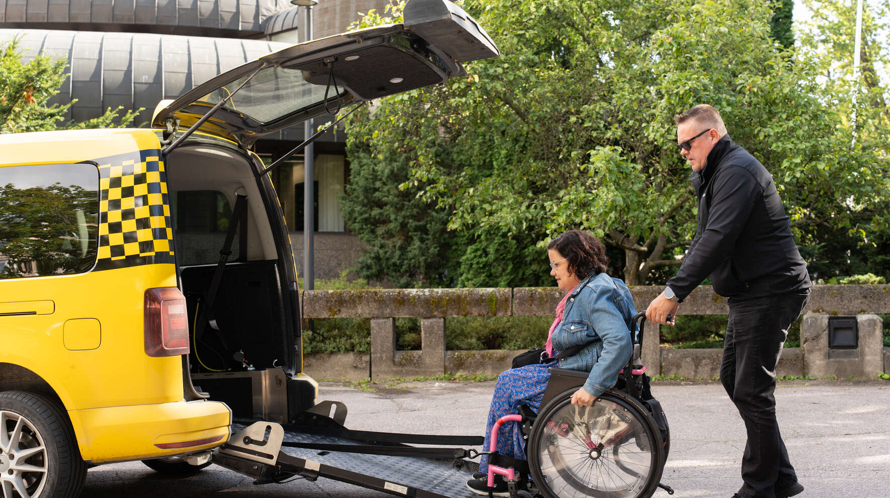 Pyörätuolilla kulkeva menee invataksiin ramppia pitkin toisen ihmisen avustuksella.