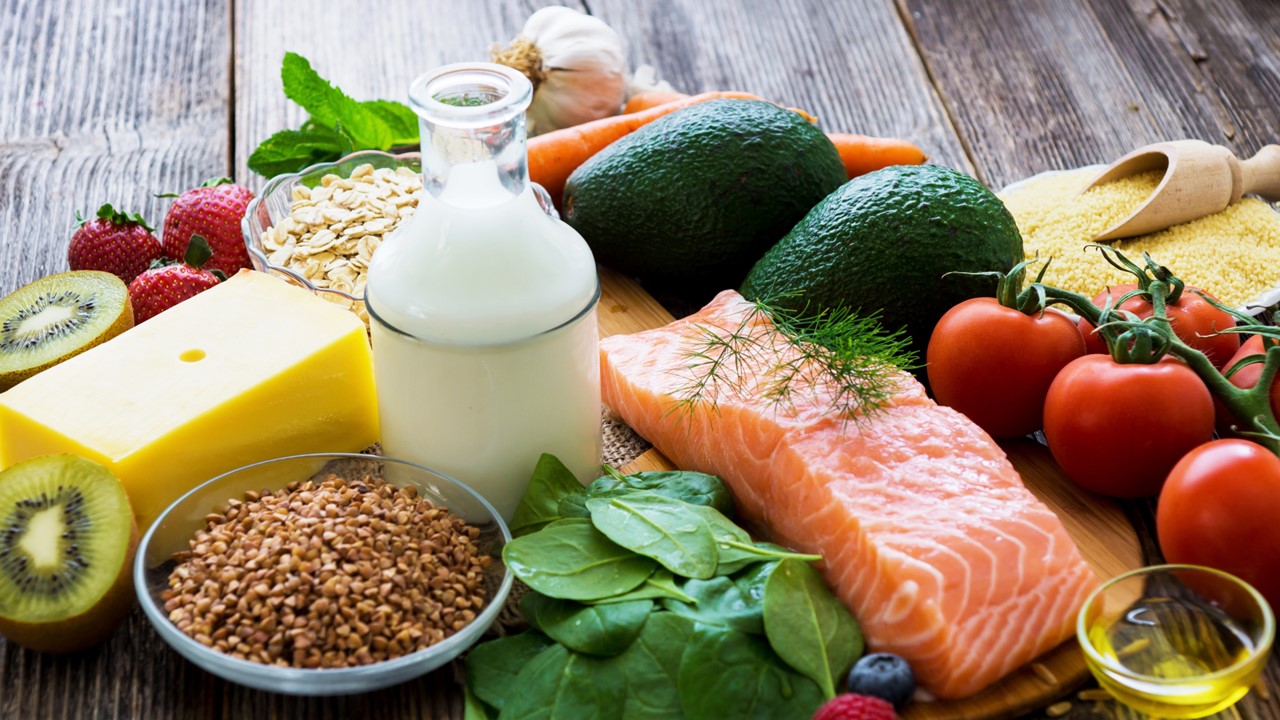 Monipuolisesti erivärisiä ruokia, kuten juustoa, siemeniä, pinaattia, lohta ja tomaatteja.