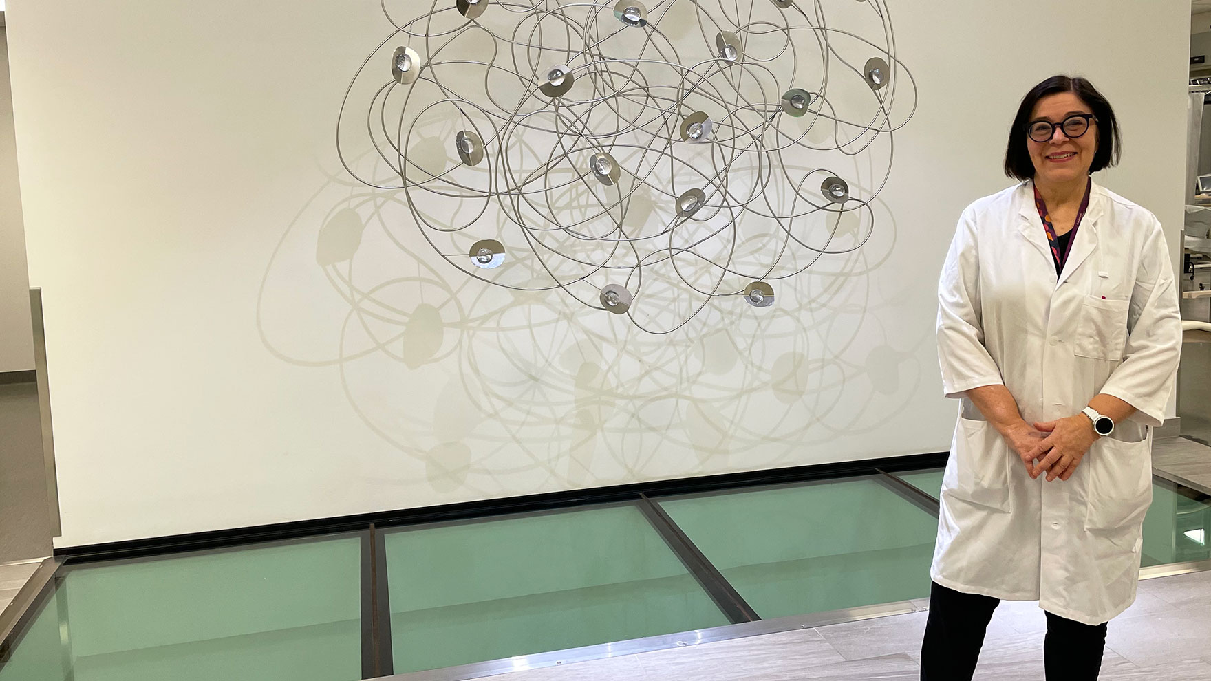Valokuva Satu Mäkelästä munuaiskeskuksen taideteoksen edessä.