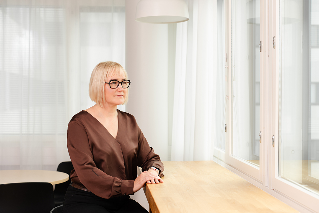 Valokuvassa Suvi Forss katsoo ulos ikkunasta.