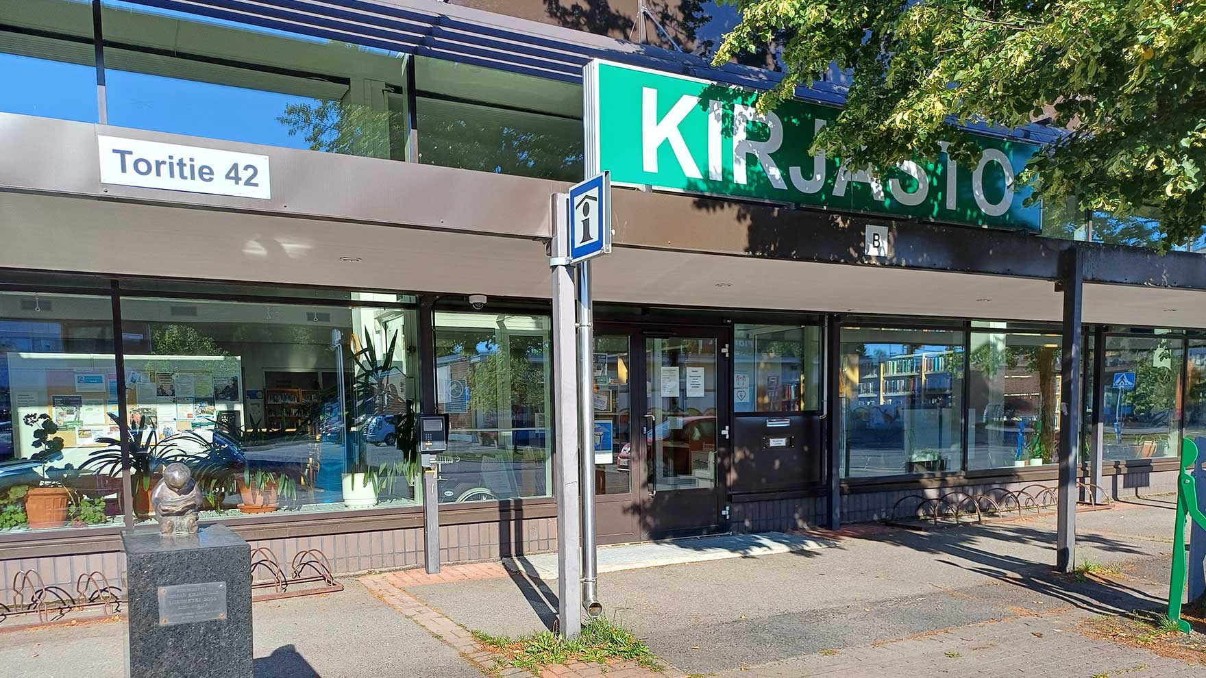 Sisäänkäynti kirjastoon, talon seinässä lukee osoite Toritie 42.