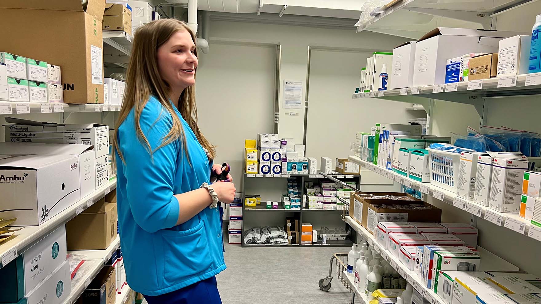 Sanni Vaskelainen seisoo varastohyllyjen välissä.