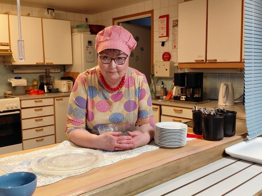 Anja Nummela nojaa keittiön tasoa vasten ja katsoo kameraan.