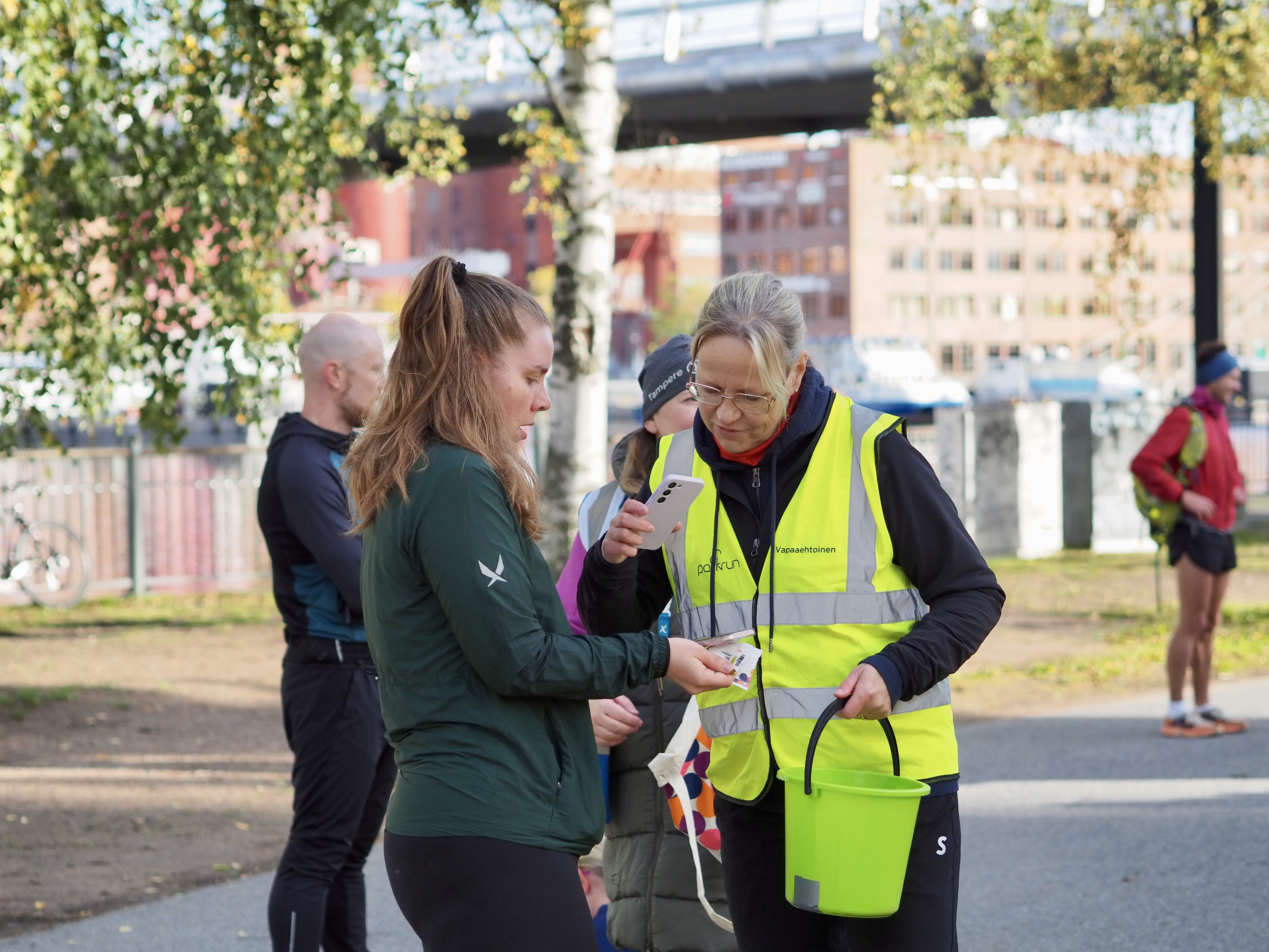Vapaaehtoinen skannaa osallistujan viivakoodin Parkrun-tapahtumassa.