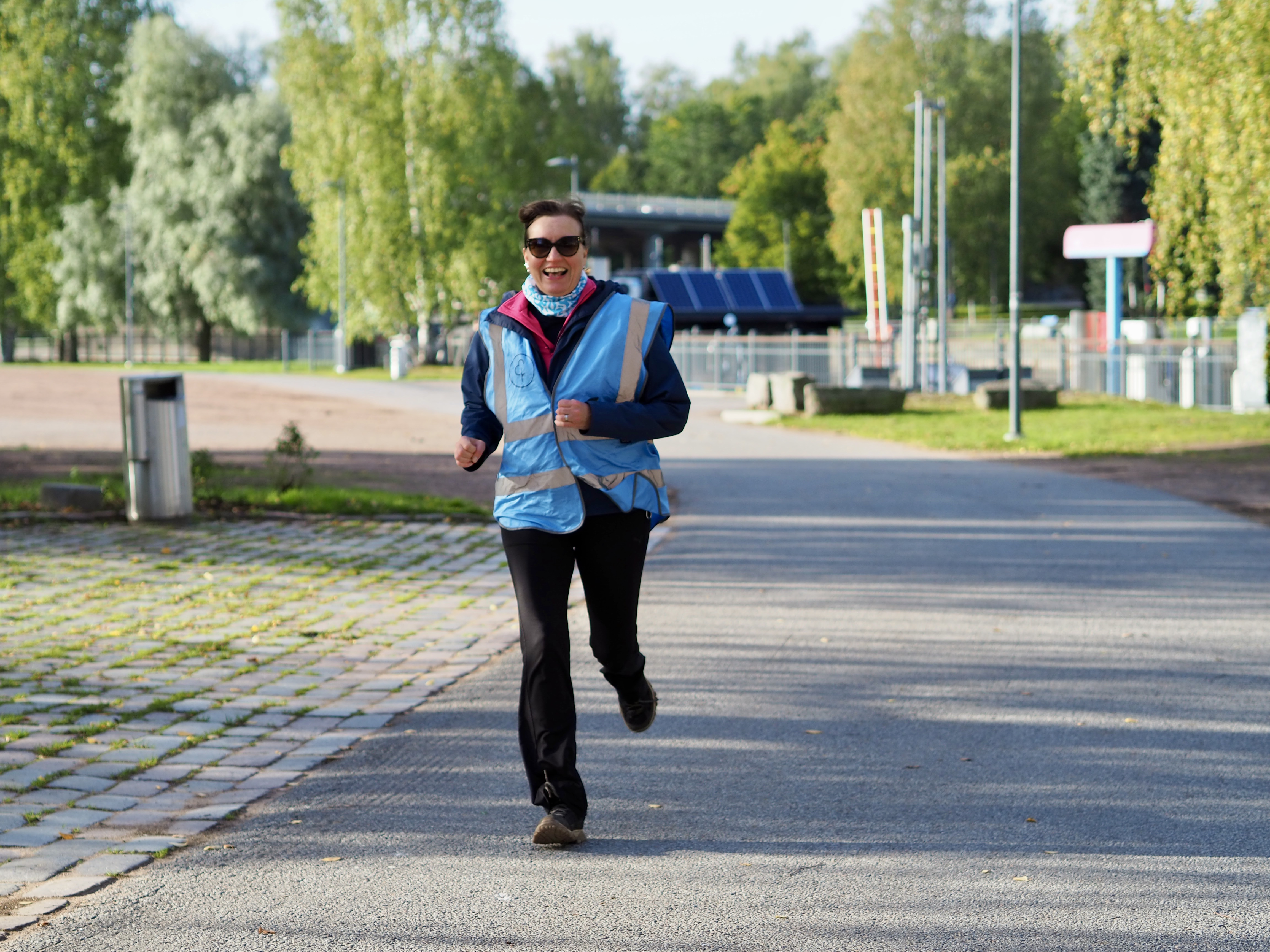 Nainen juoksee puistolla.